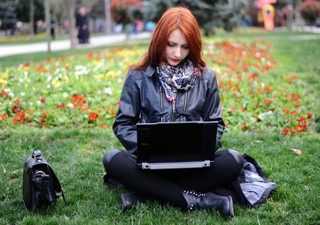 Mulher usa laptop em praça turca tentando acessar redes sociais bloqueadas pelo governo (Foto: AFP)