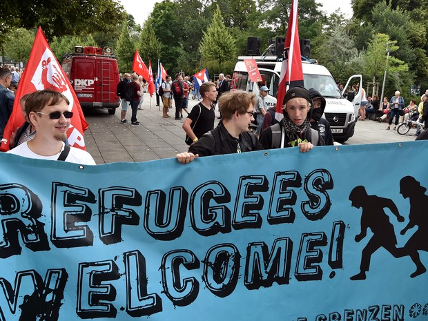 Manifestantes seguram cartaz de boas vindas a refugiados em Frankfurt an der Oder, na Alemanha (Foto: Bernd Settnik/DPA/AFP)