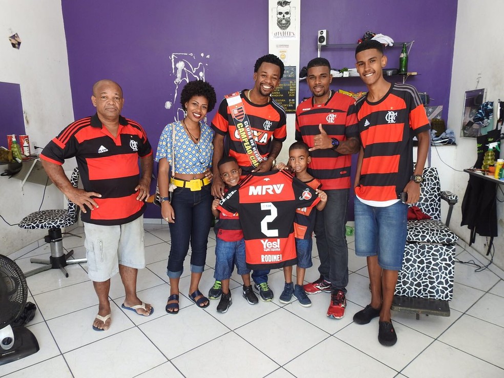 Luiz Claudio, torcedor que pegou camisa de Rodinei na comemoração do gol, em sua barbearia e com família (Foto: Fred Gomes)