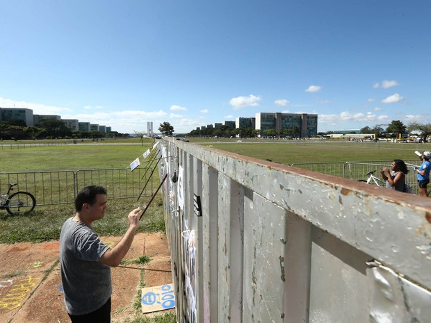 Movimentação na área dividida por um alambrado para separar os protestos pró e contra impeachment da presidente Dilma Rousseff na Esplanada dos Ministérios, em frente ao Congresso Nacional, em Brasília. O muro de metal virou mural para cartazes (Foto: Daniel Teixeira/Estadão Conteúdo)