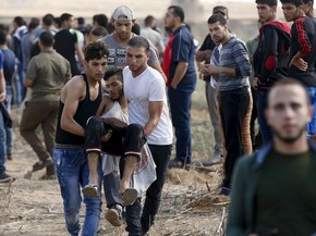 Palestinos carregam um manifestante ferido que foi baleado por soldados israelenses durante confrontos perto da fronteira israelense no nordeste de Gaza. Seis palestinos morreram (Foto: Mohammed Salem/Reuters) Palestinos carregam um manifestante ferido que foi baleado por soldados israelenses durante confrontos perto da fronteira israelense no nordeste de Gaza. Seis palestinos morreram (Foto: Mohammed Salem/Reuters)