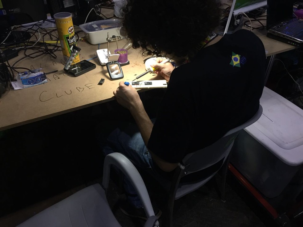 Jovem faz ajustes em circuito eletrônico (Foto: Mateus Rodrigues/G1)