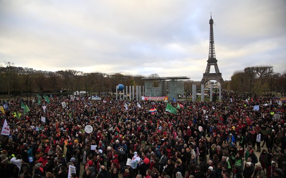 Ativistas se reúnem em Paris, França, para comemorar o primeiro acordo global contra as mudanças climáticas (Foto: Thibault Camus/AP)