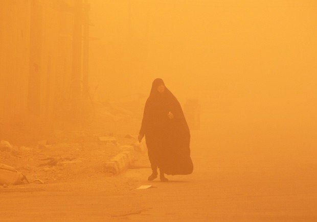 Mulher caminha em meio à tempestade de areia (Foto: Sabah Arar/AFP)