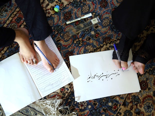 Professora aposentada, Zohreh Etezadossaltaneh ensina a escrever com os ps (Foto: Ebrahim Noroozi/AP)