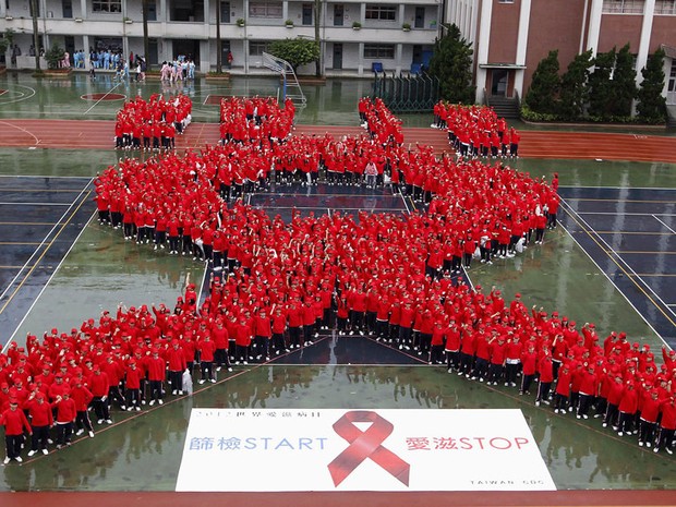 Estudantes formam o símbolo da luta contra a Aids nesta sexta-feira (30) durante ação realizada em Taipei, em Taiwan (Foto: Pichi Chuang/Reuters)