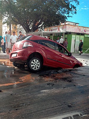 Carro fica pendurado em buraco no bairro do Imbuí, em Salvador (Foto: Priscila Ladeia/ TV Bahia)