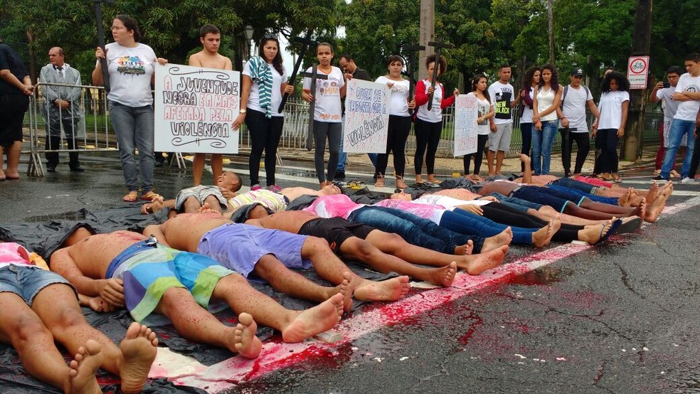 Jovens de movimento internacional se deitaram no chão e usaram tinta vermelha para lembrar as vítimas de assassinato em Pernambuco (Foto: Wanessa Andrade/ TV Globo)