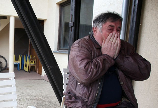 Radmilo Bogdanovic, irmão do suposto atirador, Ljubisa, chora em desespero após o massacre, em sua casa na vila de Velika Ivanca (Foto: Darko Vojinovic/AP)
