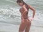 Ex-BBB Adriana se bronzeia de biquíni na praia