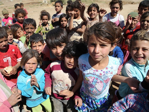 Crianças sírias posam para foto em capmo de refúgiados de Balbeek, na Líbano (Foto: Hussein Malla/AP)