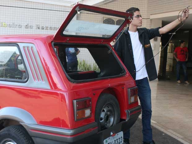 O estudante Ewerson Freitas e o carro movido a energia elétrica que adaptou durante três anos (Foto: Divulgação)