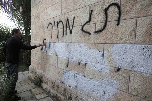 Pichação anticristã é apagada de muro em Jerusalém nesta sexta-feira (9). Inscrição foi feita pouco antes de viagem do Papa Francisco à Terra Santa (Foto: Ammar Awad/Reuters)