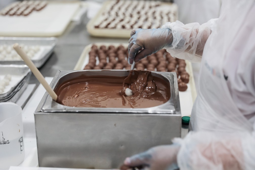 Cerejas são banhadas em chocolate durante processo de produção do bombom Cherry Brandy, da Kopenhagen  (Foto: Fábio Tito/G1)