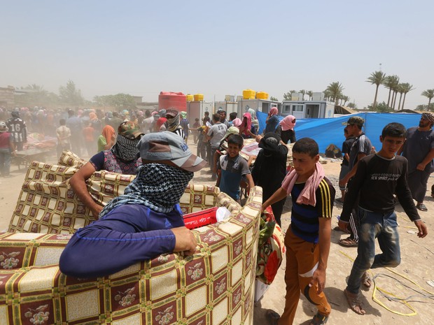 Civis refugiados recebem ajuda humanitária da ONU em um acampamento em Amiriyat al-Fallujah, no Iraque. A entidade está apressando a ajuda com alimentos para os milhares de moradores que fugiram de Ramadi após a cidade ser tomada pelo Estado Islâmico (Foto: Hadi Mizban/AP) Civis refugiados recebem ajuda humanitária da ONU em um acampamento em Amiriyat al-Fallujah, no Iraque. A entidade está apressando a ajuda com alimentos para os milhares de moradores que fugiram de Ramadi após a cidade ser tomada pelo Estado Islâmico (Foto: Hadi Mizban/AP)