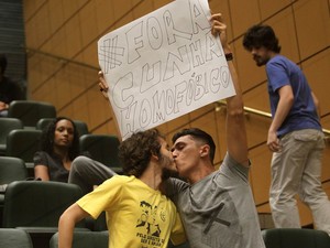 Manifestantes de grupos anti-homofobia se beijam e erguem cartaz durante protesto contra o presidente da Câmara dos Deputados, Eduardo Cunha (PMDB) (Foto: Hélvio Romero/Estadão Conteúdo)