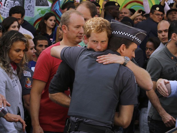 Harry abraça policial e viciados (Foto: AP Photo/Nacho Doce)