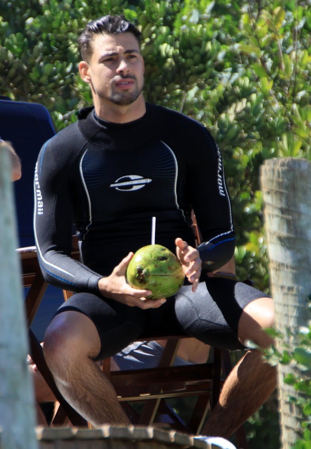 Cauã toma água de coco depois de surfar (Foto: Foto Rio News)