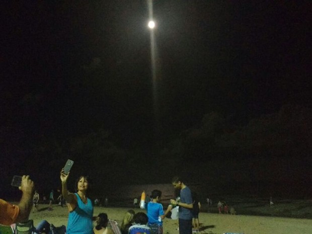 Moradores e turistas se reunem para apreciar a Super Lua na praia de Ponta Verde (Foto: Vitória de Alencar/G1)