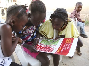 Garotas olham para poster distribuído pela Unicef sobre formas de prevenir a propagação do ebola; atualmente, não há vacina  (Foto:  Reuters/Ahmed Jallanzo/Unicef)