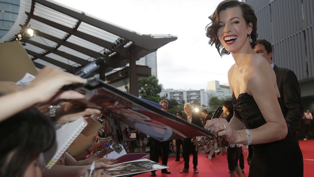 Milla Jovovich acena durante 'Resident Evil: Retribution' em Tóquio, nesta segunda-feira (3) (Foto: AP/Shizuo Kambayashi)