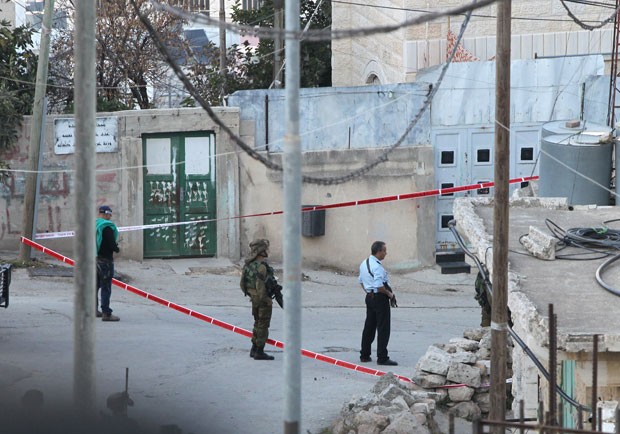  Policiais israelenses fazem guarda em local onde palestino tentou atacar soldado de Israel e acabou morto nesta quinta-feira (29) em Hebron, na Cisjordânia (Foto: Hazem Bader/AFP)
