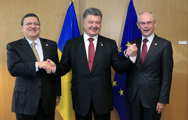 O presidente da Ucrânia, Petro Poroshenko (ao centro), comemora a assinatura de um acordo com a União Europeia ao lado do presidente da Comissão Europeia, José Manuel Barroso (à esquerda), e do presidente do Conselho Europeu, Herman Van Rompuy (à direita), nesta sexta-feira (27) em Bruxelas (Foto: Reuters)