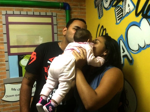 Magno Lucas e Steffany dão um beijo na filha Bianca, portadora de microcefalia (Foto: Lívia Torres / G1)