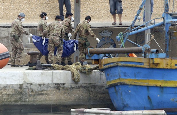 Soldados italianos carregam corpos de vítimas do naufrágio neste domingo (6) em Lampedusa (Foto: Reuters)
