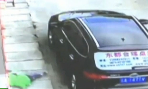 Menino de 3 anos teve apenas arranhões após cair do terceiro andar de um prédio e atingir um carro antes de chegar ao chão na China (Foto: Reprodução/YouTube/RT)
