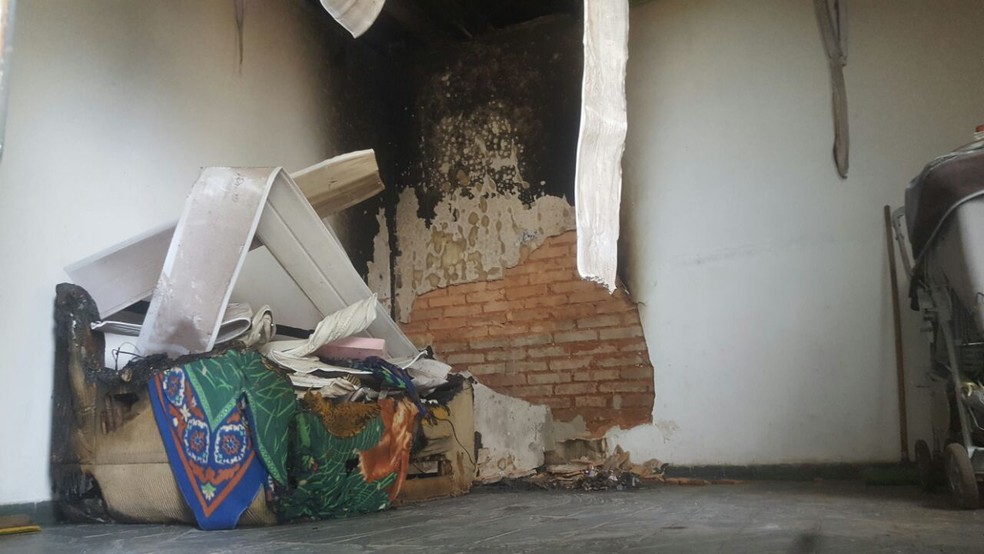 Sof&aacute; ficou destru&iacute;do e chamas atingiram teto da sala (Foto: Edmar Melo/ TV Morena)