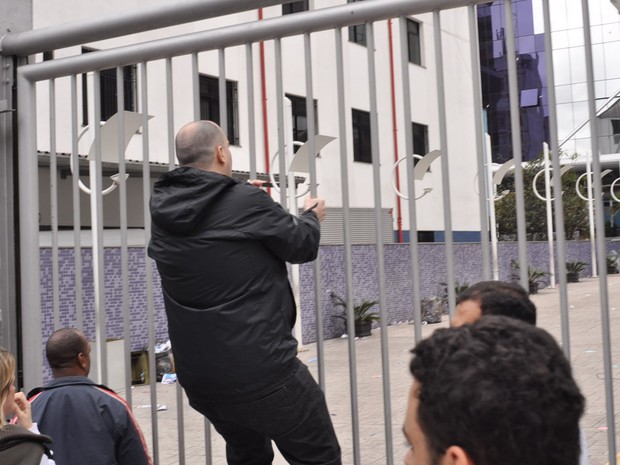 Canditado que chegou atrasado se revolta, sobe no portão e grita contra os seguranças e funcionários da OAB (Foto: Guilherme Tosetto/G1)