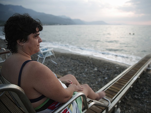 Matoula Kastrioti, de 46 anos, que sofre de esclerose múltipla, observa praia em Alepochori (Foto: Yorgos Karahalis/Reuters)
