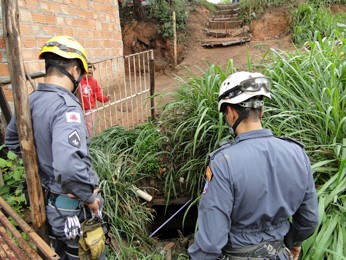 Bombeiros observam tubulação de esgoto onde mulher foi resgatada (Foto: Pedro Triginelli/G1)