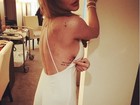 Lindsay Lohan exibe lateral dos seios ao mostrar tatuagem