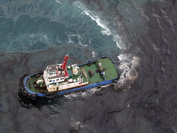 Vazamento de óleo, imagem de embarcações limpando o petróleo derramado no mar 