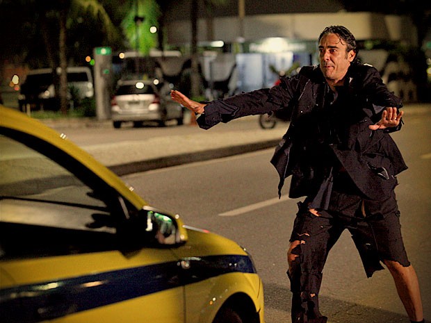 Com as roupas rasgadas, Cadinho tenta pegar um táxi para se livrar de vexame (Foto: Avenida Brasil / TV Globo)