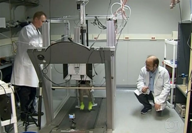 O cientista Miguel Nicolelis (à direita) observa macaco caminhando em esteira durante experimento (Foto: Reprodução/TV Globo)