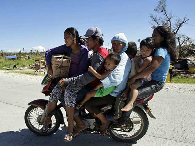 Motociclista transporta mais seis pessoas, todas da mesma família, para apanhar suprimentos na cidade costeira de Banganga, arrasada pela tormenta. (Foto: Erik de Castro / Reuters)