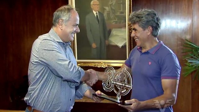 Roberto Santini, presidente da TV Tribuna, entrega o prêmio para Paulo Antonio (Foto: Reprodução/TV Tribuna)