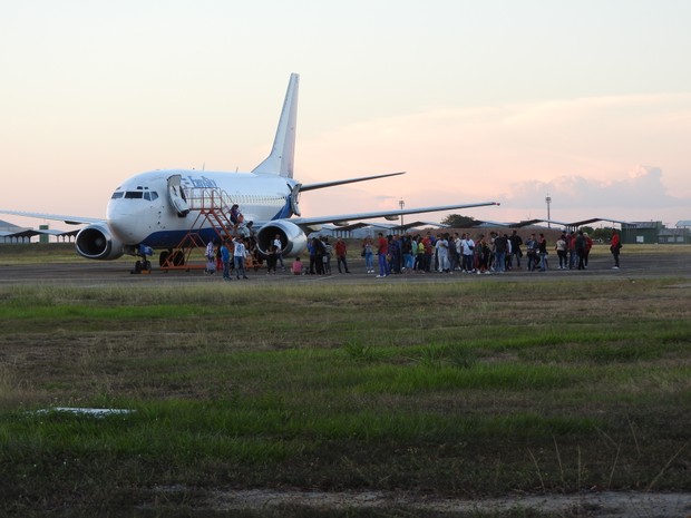 Passageiros do voo 8039 desembarcam no Aeroporto Internacional de Boa Vista (Foto: Valéria Oliveira/G1)