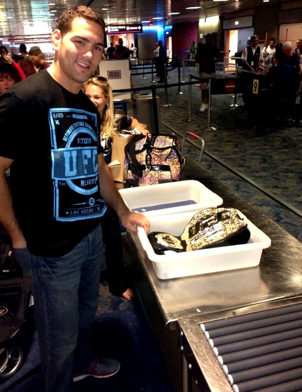 Chris Weidman passando o cinturão na esteira do aeroporto (Foto: Reprodução / Instagram)