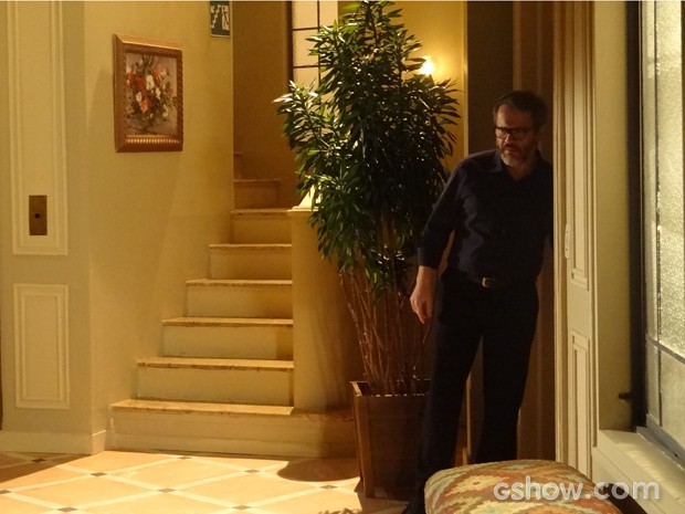 Nando fica atrás da porta ouvindo a briga do casal (Foto: Em Família / TV Globo)