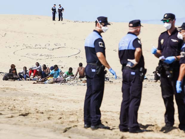 Grupo de africanos sob suspeita de ebola foi isolado pela polícia em praia das Ilhas das Canárias enquanto esperava a chegada de médicos (Foto: REUTERS/Borja Suarez)