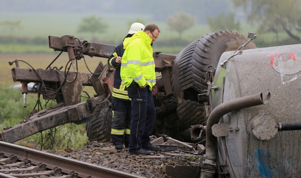Policial e bombeiro observam o caminhão destruído após o acidente com um trem na Alemanha (Foto: Marcel Kusch/DPA/AFP)