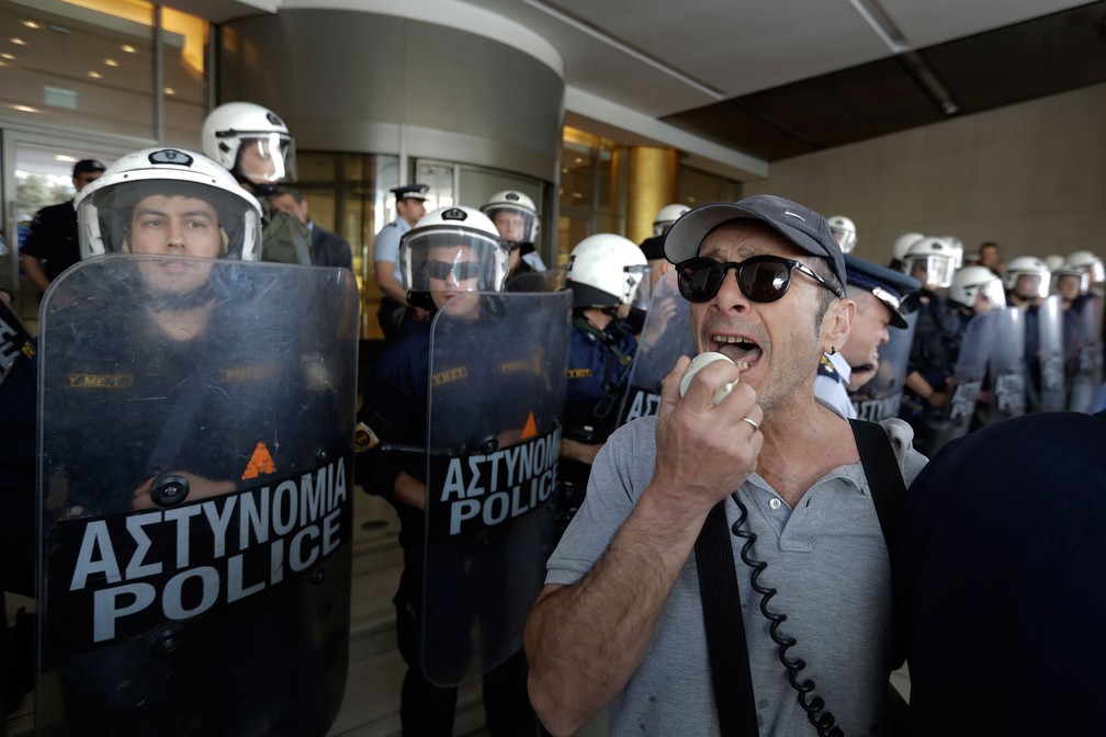 Manifestantes protestam perto de policiais durante marcha pelo Dia do Trabalhador em Atenas, na Grécia, nesta segunda-feira, dia 1º de maio de 2017 (Foto: Thanassis Stavrakis/AP)