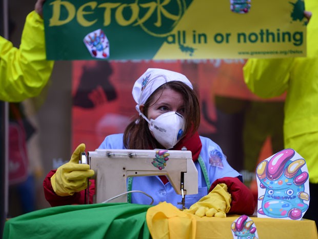 Ativista do Greenpeace faz protesto para alertar presença de produtos tóxicos em roupas infantis (Foto: Attila Kisbenedek/AFP)