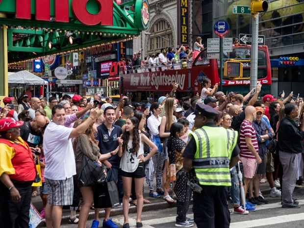 Multidão se reúne na 8ª Avenida, em Nova York, para observar o presidente Barack Obama e suas filhas, Sasha e Malia, enquanto eles se dirigem ao Richard Rodgers Theatre (Foto: AP Photo/Andrew Harnik)