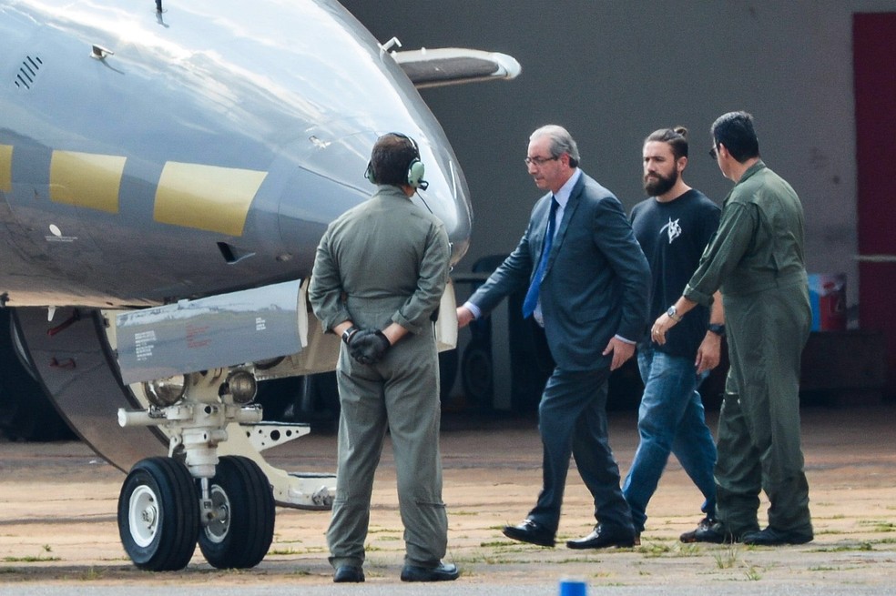 O deputado cassado e ex-presidente da Câmara é conduzido ao avião da Polícia Federal que o levou em outubro para a prisão em Curitiba (Foto: Wilson Dias/Agência Brasil)