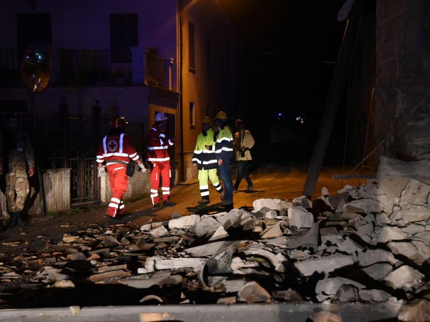 Bombeiros e funcionários de emergência são vistos próximos a escombros na vila de Visso, na Itália, após terremoto atingir o local na quarta (26) (Foto: Matteo Crocchioni/ANSA via AP)